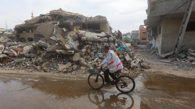 War took a Gaza doctor's car. Now he uses a bike to get to patients, sometimes carrying it over rubble.